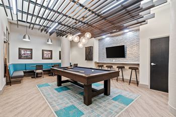 The game lounge, including billiards, foosball, darts, tvs, lounge chairs, and tables